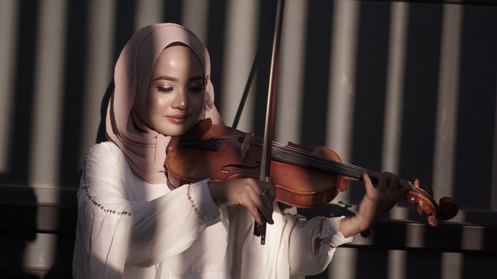 Student in hijab playing violin