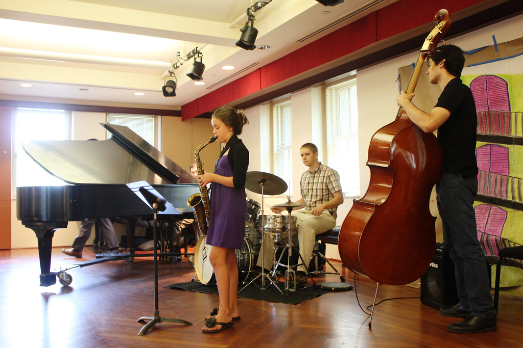 Student performing saxophone in a school recital ensemble
