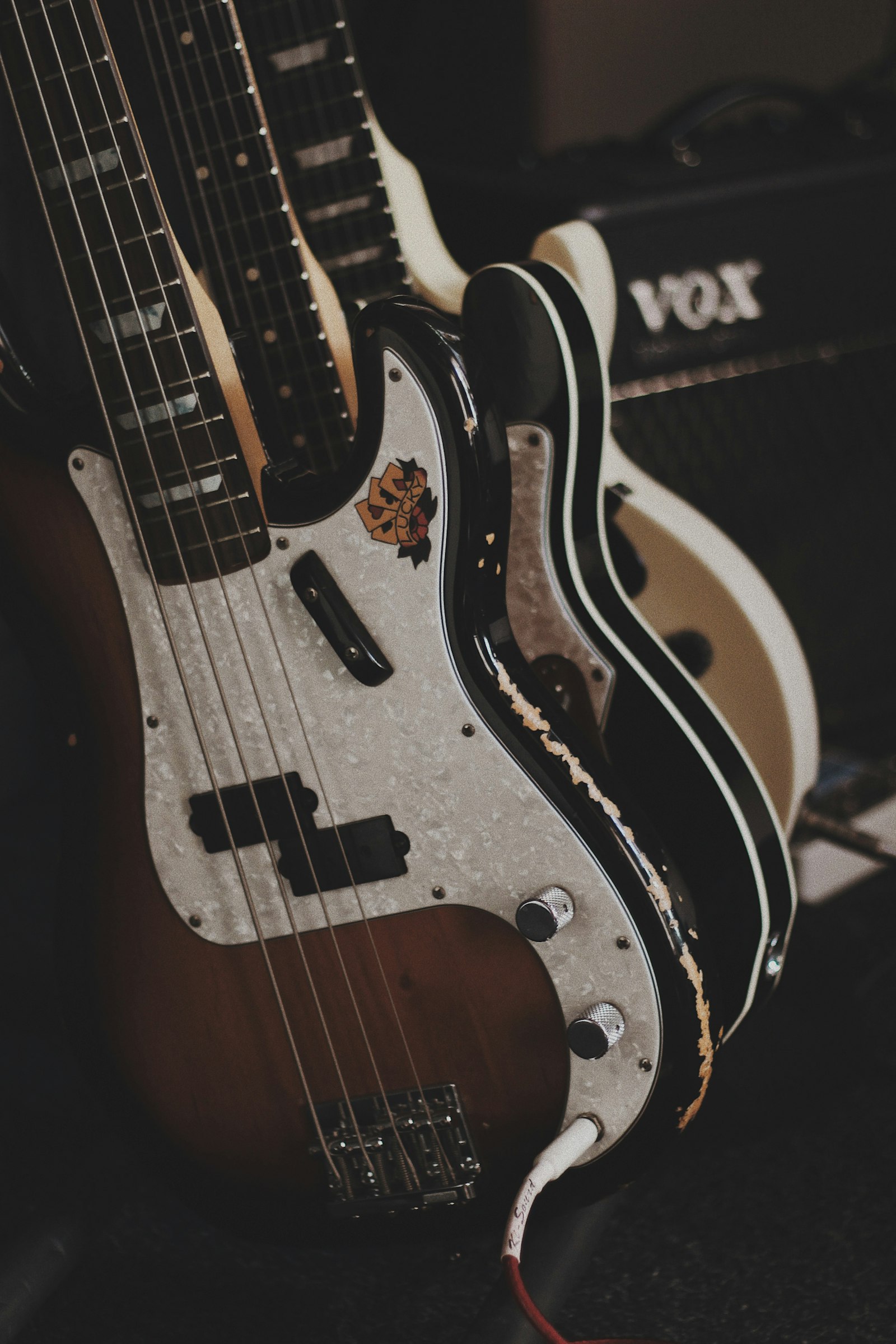 Electric bass guitars resting against an amp