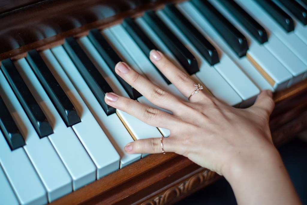 Close-up of a hand playing piano keys during a music lesson