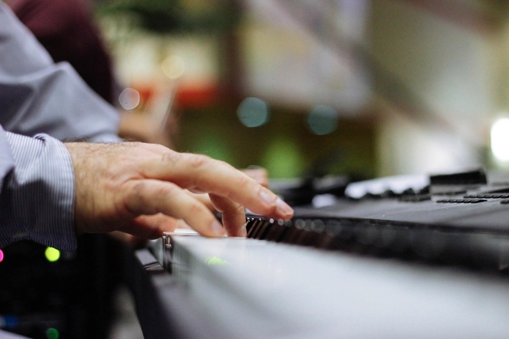 Close-up of a hand playing piano keys